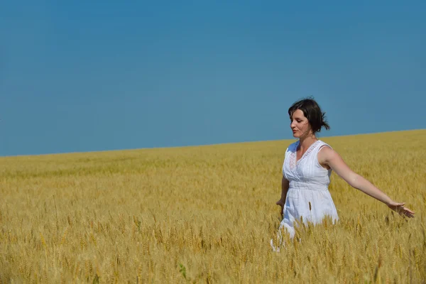 Junge Frau im Weizenfeld im Sommer — Stockfoto