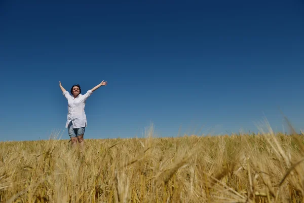 Junge Frau im Weizenfeld im Sommer — Stockfoto