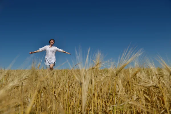 Junge Frau im Weizenfeld im Sommer — Stockfoto