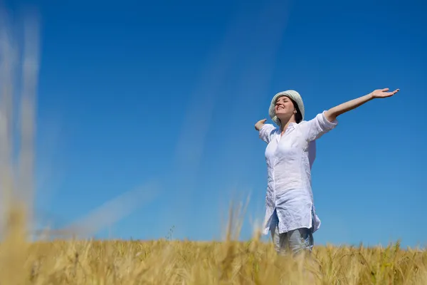 Junge Frau im Weizenfeld im Sommer — Stockfoto