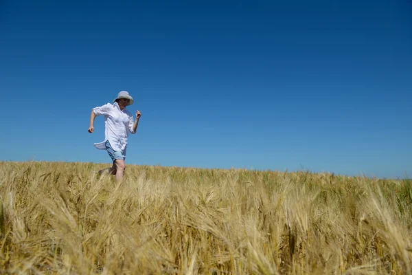 Mujer joven en el campo de trigo en verano — Foto de Stock