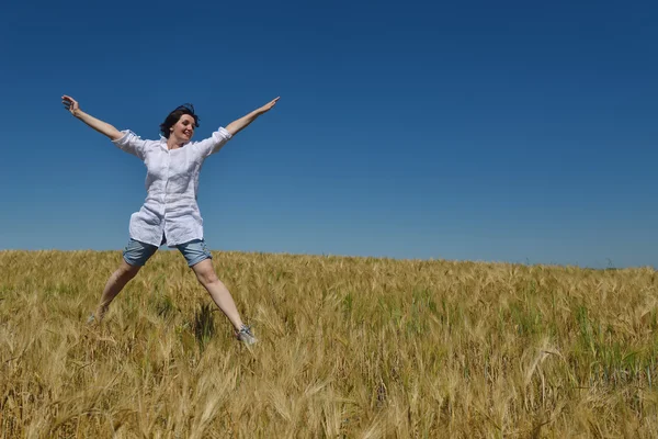 Junge Frau im Weizenfeld im Sommer — Stockfoto