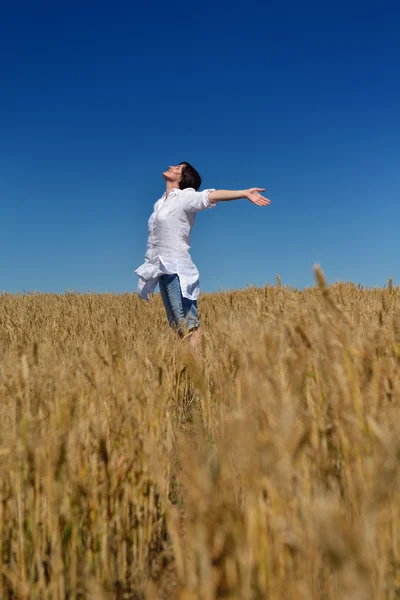 Junge Frau im Weizenfeld im Sommer — Stockfoto