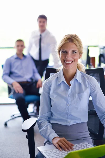 Business woman with her staff in background at office — Stock Photo, Image