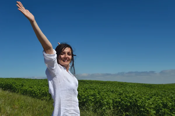 Jovem mulher feliz no campo verde — Fotografia de Stock