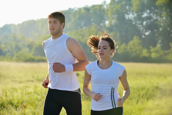 Unga par joggar på morgonen — Stockfoto