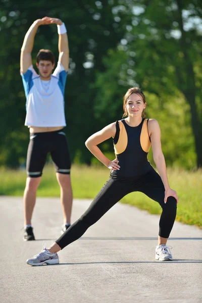 Par som stretchar efter jogging — Stockfoto