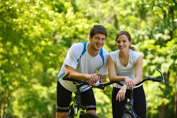 Счастливая пара катается на велосипеде на открытом воздухе — стоковое фото
