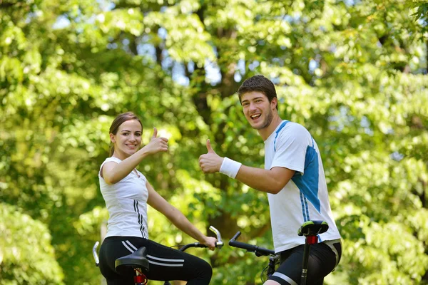 Happy couple riding bicycle outdoors — Stock Photo, Image