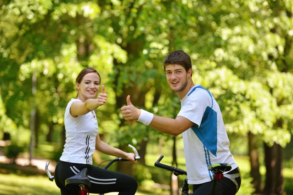 Happy couple riding bicycle outdoors — Stock Photo, Image