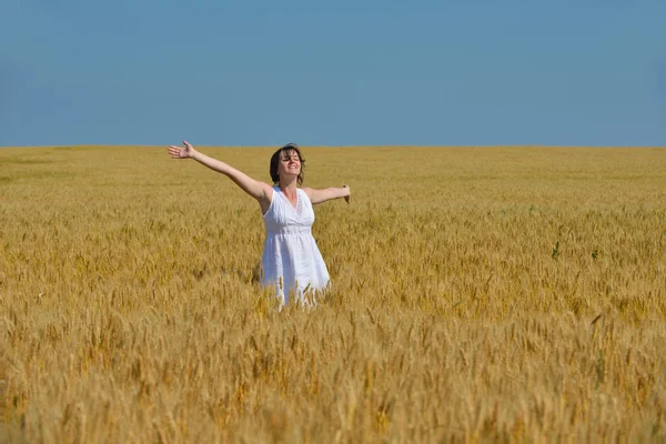 Mujer joven en el campo de trigo en verano — Foto de Stock