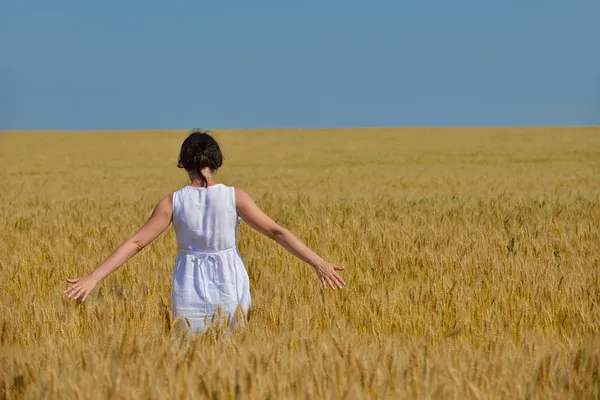 Jovem mulher no campo de trigo no verão — Fotografia de Stock