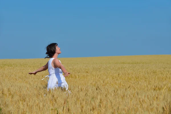 Mujer joven en el campo de trigo en verano — Foto de Stock