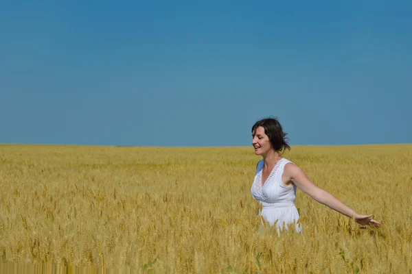 Mujer joven en el campo de trigo en verano — Foto de Stock