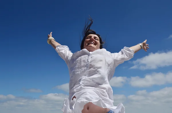 Happy young woman with spreading arms to sky — Stock Photo, Image