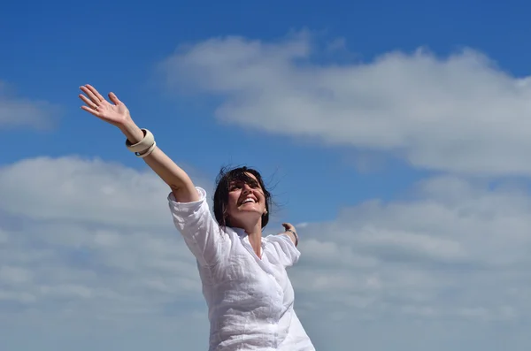 Happy young woman with spreading arms to sky — Stock Photo, Image