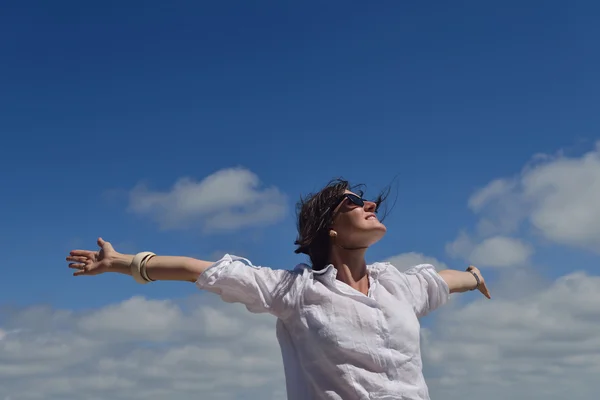 Happy young woman with spreading arms to sky — Stock Photo, Image