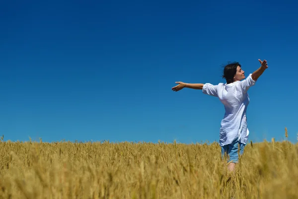 Mujer joven en el campo de trigo en verano — Foto de Stock