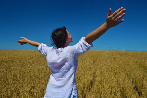 Jovem mulher no campo de trigo no verão — Fotografia de Stock