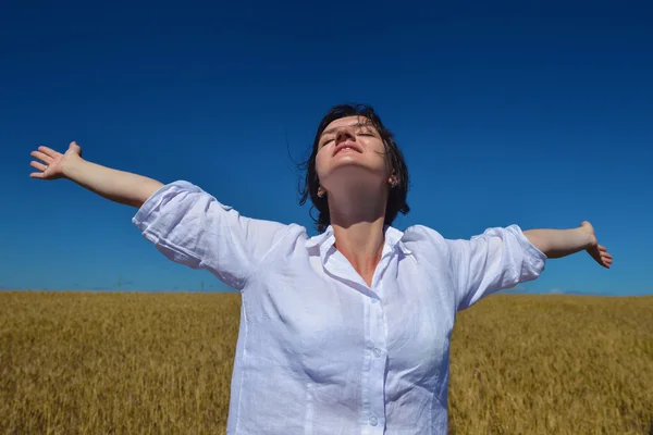 Mujer joven en el campo de trigo en verano — Foto de Stock