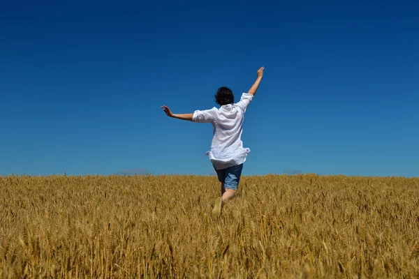 Young woman in wheat field at summer — Stock Photo, Image