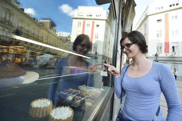 Donna davanti alla finestra del negozio dolce — Foto Stock