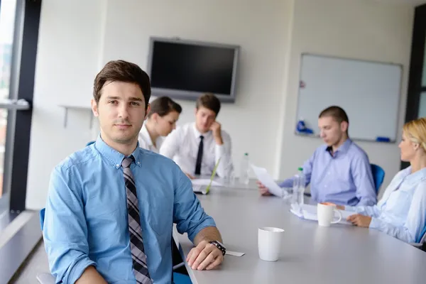 Homem de negócios em uma reunião em offce com colegas em backgroun — Fotografia de Stock