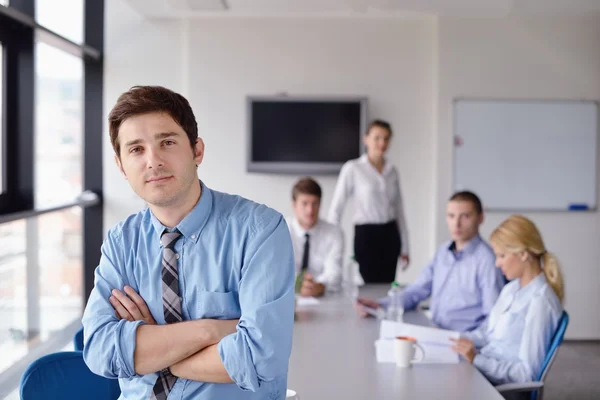 Zakenman op een bijeenkomst in offce met collega's in de pagina — Stockfoto