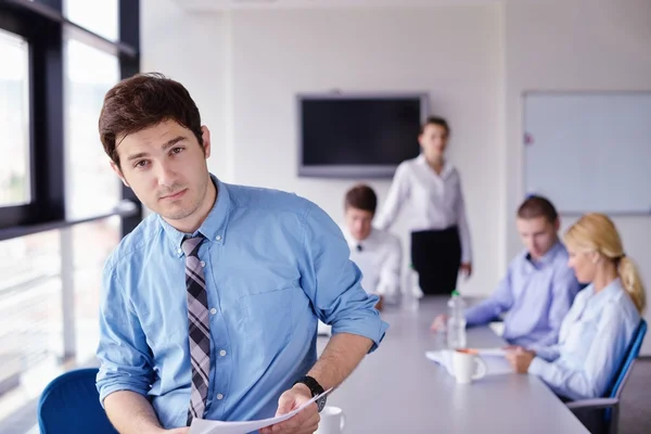 Zakenman op een bijeenkomst in offce met collega's in de pagina — Stockfoto