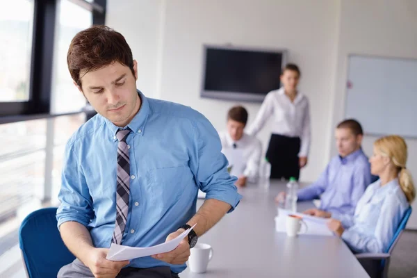 Hombre de negocios en una reunión en offce con colegas en backgroun — Foto de Stock