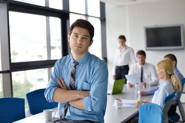 Zakenman op een bijeenkomst in offce met collega's in de pagina — Stockfoto