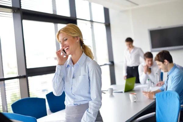 Zakenvrouw met haar personeel op achtergrond op kantoor — Stockfoto