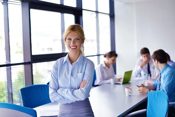 Business woman with her staff in background at office — Stock Photo, Image