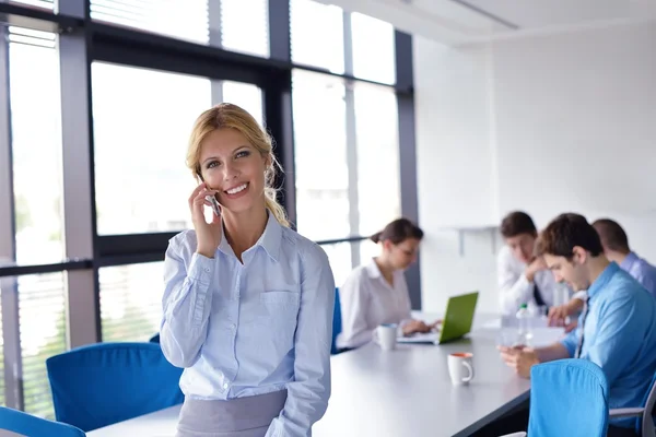 Business woman with her staff in background at office — Stock Photo, Image