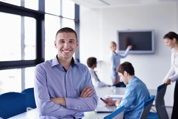 Zakenman op een bijeenkomst in offce met collega's in de pagina — Stockfoto