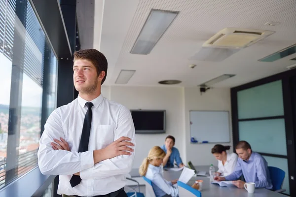 Uomo d'affari in un incontro in ufficio con i colleghi nel backgroun — Foto Stock