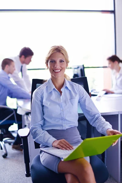 Business woman with her staff in background at office — Stock Photo, Image