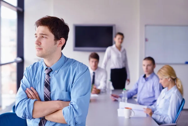 Zakenman op een bijeenkomst in offce met collega's in de pagina — Stockfoto