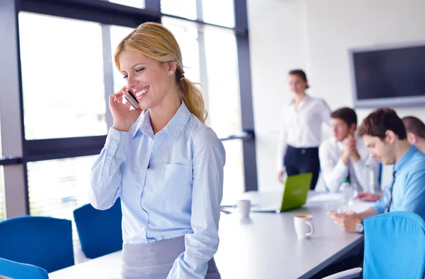 Femme d'affaires avec son personnel en arrière-plan au bureau — Photo