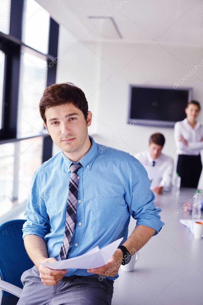 business man on a meeting in offce with colleagues in backgroun