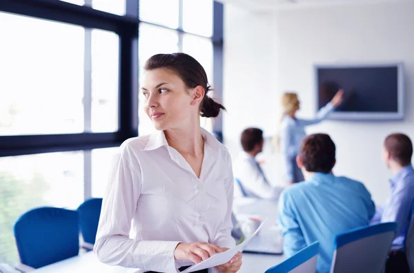 Business woman with her staff in background at office — Stock Photo, Image