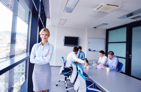 Mujer de negocios con su personal en segundo plano en la oficina — Foto de Stock