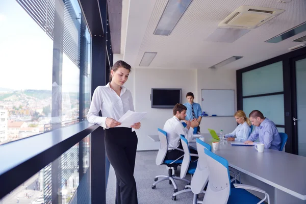 Affärskvinna med hennes personal i bakgrunden på kontor — Stockfoto