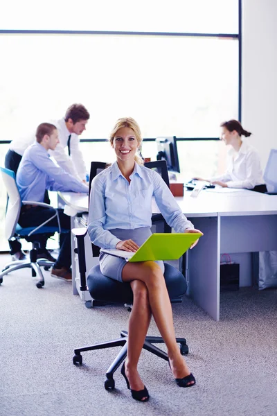 Business woman with her staff in background at office — Stock Photo, Image