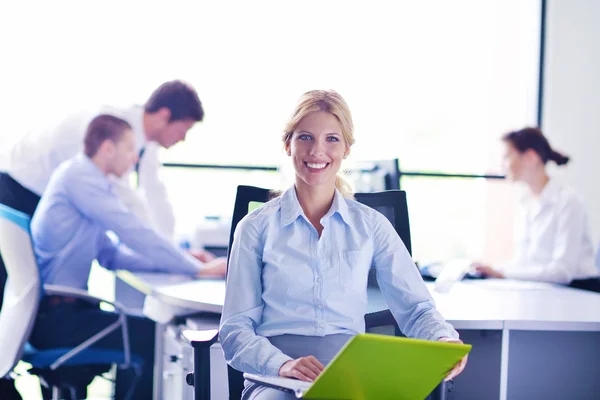 Geschäftsfrau mit ihren Mitarbeitern im Hintergrund im Büro — Stockfoto