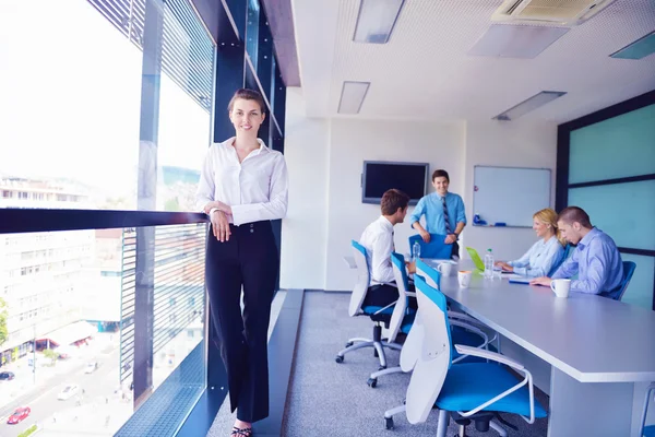 Mujer de negocios con su personal en segundo plano en la oficina —  Fotos de Stock