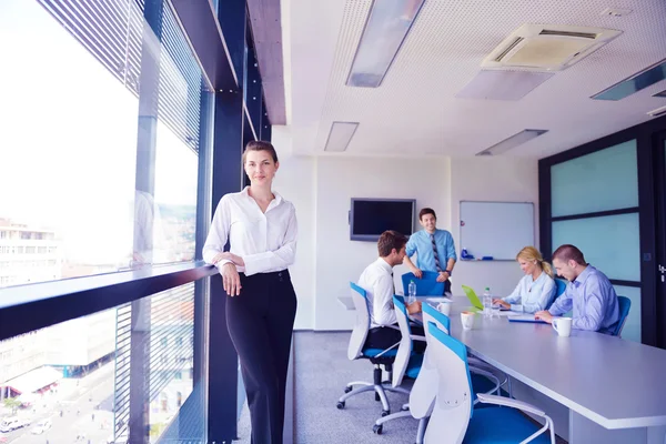 Mujer de negocios con su personal en segundo plano en la oficina — Foto de Stock