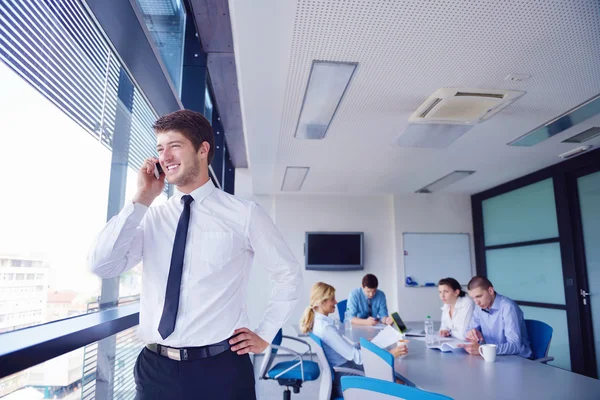 Uomo d'affari in un incontro in ufficio con i colleghi nel backgroun — Foto Stock