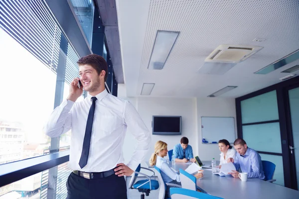 Zakenman op een bijeenkomst in offce met collega's in de pagina — Stockfoto