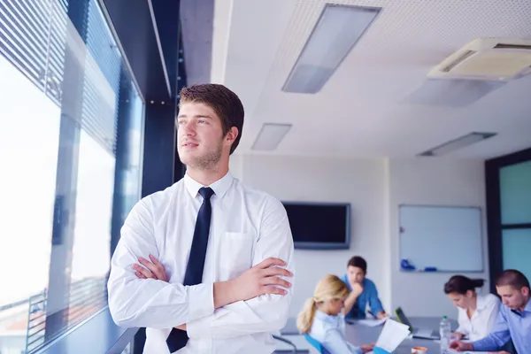 Business man on a meeting in offce with colleagues in backgroun — Stock Photo, Image